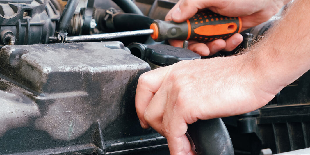 Auto Mechanic Working On Car Engine In Mechanics Garage. Repair