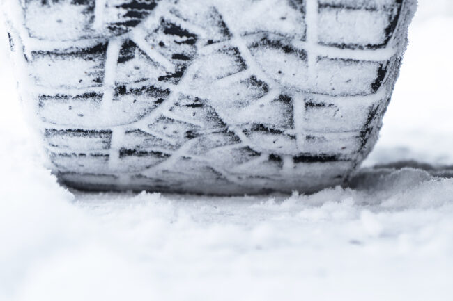 Car Tire In The Snow Close Up. Car Tracks On The Snow. Traces Of