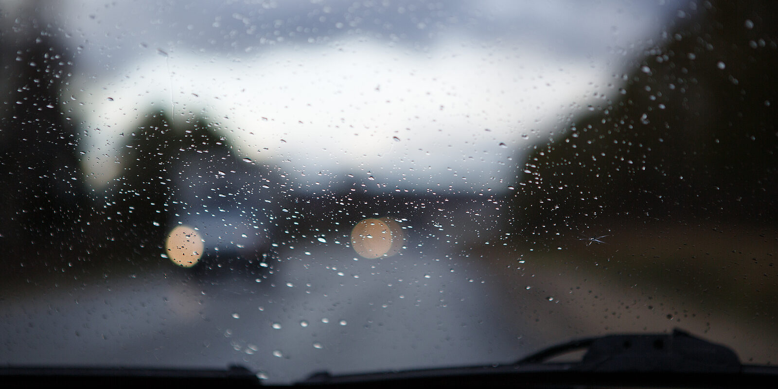 The Car Window Is Wet With Raindrops. Through The Windshield Vie