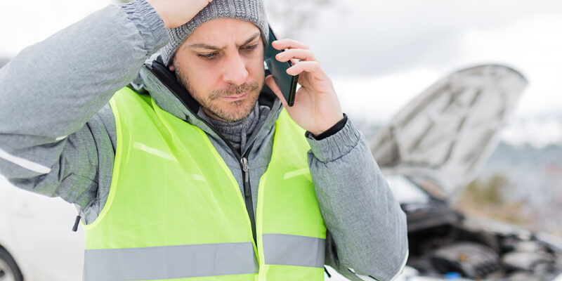 Stressed Man In Reflective Vest Calling Road Assistance Service