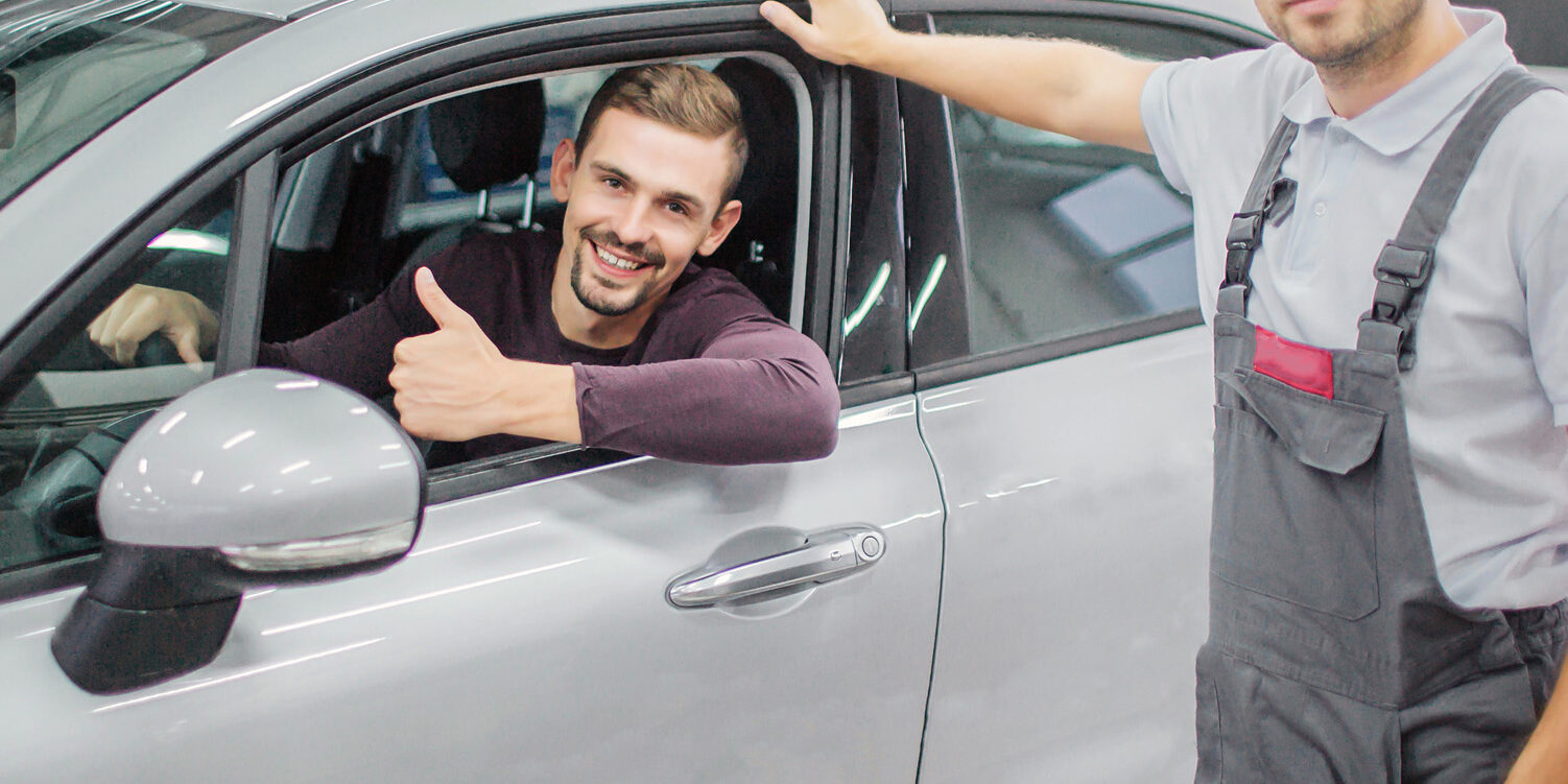 Happy Owner Sits In Car And Smiles. He Holds His Big Thumb Up. W