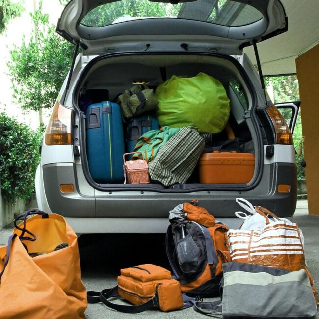 Colocar un objeto dentro del habitáculo y no en el maletero puede ocasionar lesiones Cada vez que realizamos un viaje en coche, como ahora en verano, es cuando llevamos nuestros vehículos con más carga y, colocarla correctamente puede influir en el comportamiento del vehículo ante una curva, frenadas bruscas u otras maniobras inesperadas. Por eso la Dirección General de Tráfico (DGT) pone en alerta a los conductores para que no sobrecarguen sus vehículos o transporten su carga de forma incorrecta pudiendo sancionar a quienes lo cometan. Colocar mal nuestra carga incrementa más las posibilidades de sufrir un accidente. Además, transportar bolsas o maletas en los asientos traseros conlleva una multa de 200 euros. Tampoco debemos dejar nada sobre la bandeja trasera, ya que, en caso de frenada, estos objetos pueden venirse contra nosotros a gran velocidad produciendo accidentes incluso mortales. Para evitar cualquier accidente con la carga de tus viajes, solo tienes que recordar estos consejos: No sobrecargar el vehículo, porque además de poner en riesgo la seguridad de los ocupantes, afecta a su comportamiento en frenadas y giros siendo casi un 12% más lento y torpe, haciendo que crezcan las posibilidades de perder el control y accidentarlo. Evita la carga suelta en el habitáculo por muy liviana que sea. Si chocamos frontalmente, contra, por ejemplo, una farola, dentro del habitáculo se produce una gran deceleración y el peso de los objetos se multiplica al proyectarse hacia delante. Por ejemplo, si llevamos un paraguas de 200 gramos en la bandeja y chocamos frontalmente a 60km/h, vendrá hacia nosotros con una fuerza de más de 22 kg. Debemos colocar todo el equipaje en el maletero, de tal forma que los objetos más pesados y voluminosos queden al fondo y tengamos acceso a los objetos que podamos necesitar durante el viaje. En caso de tener poco espacio en el maletero, siempre nos vendrá muy bien un portaequipajes de techo o podremos emplear una baca, aunque debemos cerciorarnos de que todo esté bien anclado antes de empezar la carga para no ponernos en peligro ni nosotros ni el resto de los usuarios de la vía.